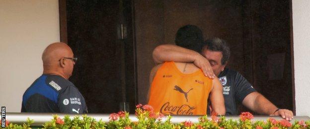 Suarez embraces a member of the Uruguay coaching set-up at the team's hotel in Natal on Thursday