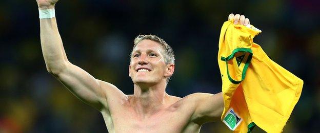 Bastian Schweinsteiger holds a Brazil shirt aloft
