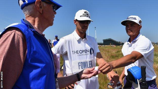 Course marshal Bill Davies (left) receives a golf ball from Rickie Fowler (right)