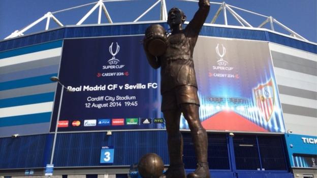 The Fred Keenor statue outside the Cardiff City stadium in front of the banner for the Uefa Super Cup.