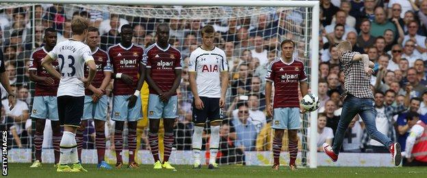 A fan, who has invaded the pitch, takes a free-kick in the West Ham v Tottenham game