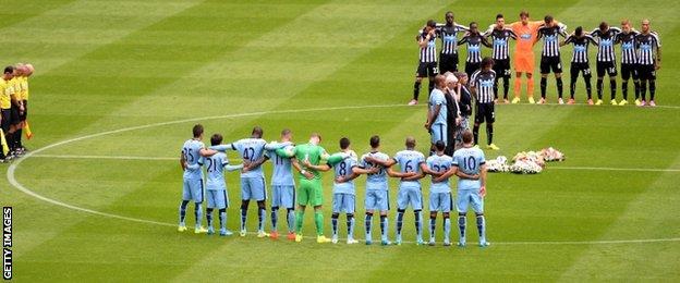 Manchester City and Newcastle United players gather in the centre circle to pay tribute along with the crowd at St James' Park to Magpies fans Liam Sweeney and John Alder