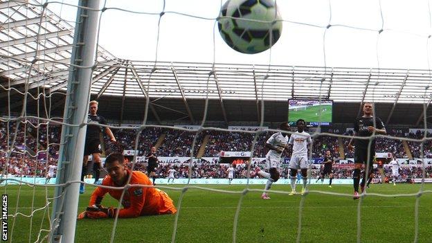 Burnley goalkeeper Tom Heaton looks on as Nathan Dyer scores for Swansea