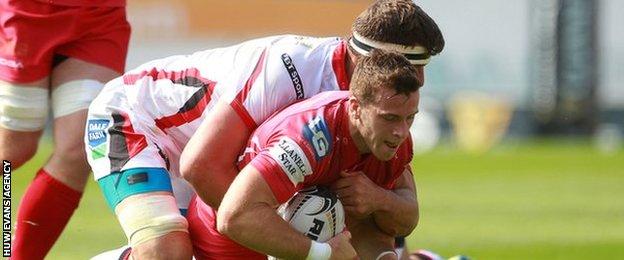 Gareth Davies of Scarlets is tackled by Robbie Diack and Callum Black of Ulster