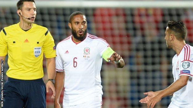 Ashley Williams and Neil Taylor talk to Referee Slavko Vincic following the Andorra penalty
