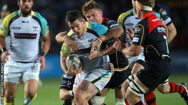 Aaron Jarvis of Ospreys is tackled by Lewis Evans