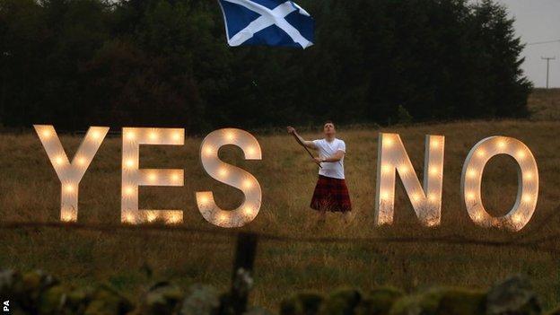 A man asks the question YES or NO with illuminated signs near Dunblane, Scotland