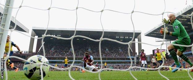 Aston Villa defender Aly Cissokho watches on as he scores an own goal in the game against Arsenal