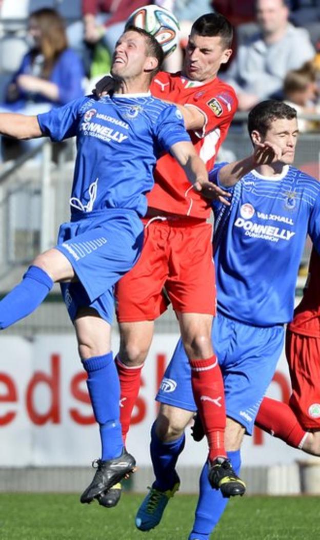Dungannon Swifts defender Terry Fitzpatrick and Cliftonville's Johnny Flynn contest a high ball in the Solitude encounter