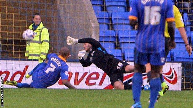 Newport goalkeeper Joe Day dives full length to deny Shrewsbury