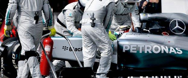 Lewis Hamilton is pushed back into the garage after retiring during the Belgian Grand Prix