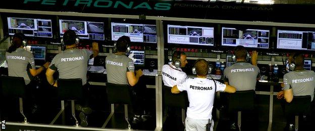 Nico Rosberg watches from pit wall after retiring from Singapore Grand prix