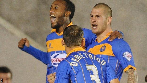 Cameron Gayle (left) and Mickey Demetriou celebrate Shrewsbury's League Cup winner with scorer James Collins