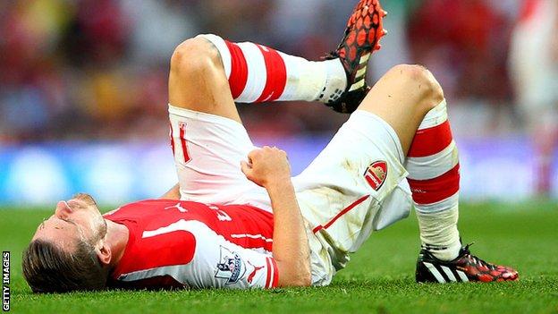 Aaron Ramsey lies on the ground after injuring himself in the north London derby