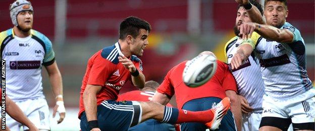 Ospreys scrum-half Rhys Webb charges down the kick of Munster's Conor Murray