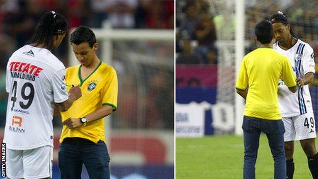 Ronaldinho is approached by a fan for an autograph during open play