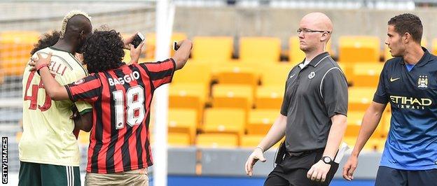 Mario Balotelli poses for a selfie during a pre-season game, much to the bemusement of stadium officials