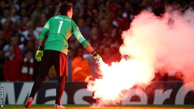Flares are thrown on to the pitch at Arsenal