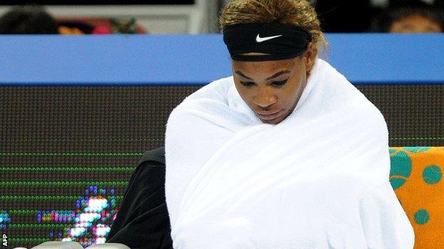 Serena Williams looks pensive as she sits wrapped in a towel during her third-round win over Lucie Safarova in Beijing