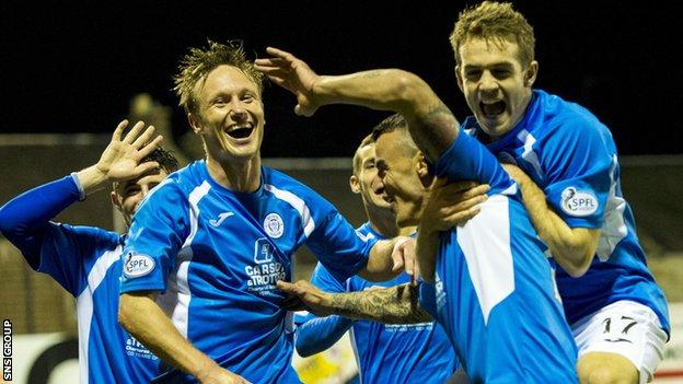 Derek Lyle is mobbed by team-mates after heading Queen of the South into a 3-2 lead