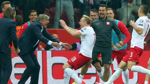 Poland's Sebastian Mila celebrates scoring his team's second goal with head coach Adam Nawalk