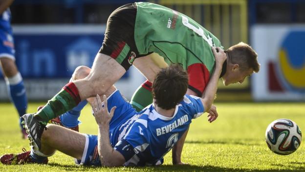 Coleraine skipper Howard Beverland goes to ground as he challenges Glentoran opponent Marcus Kane at the Showgrounds