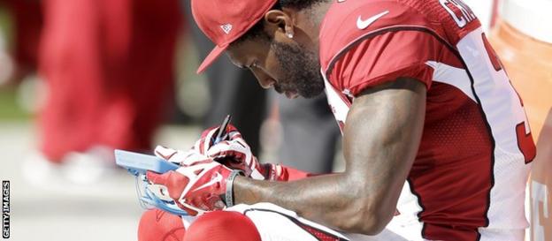 Antonio Cromartie of the Arizona Cardinals consults his tablet during a game against the Oakland Raiders