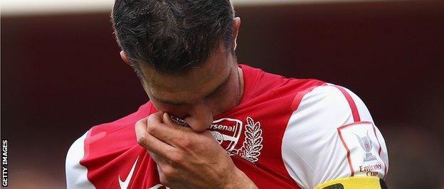 Robin van Persie kisses the Arsenal badge