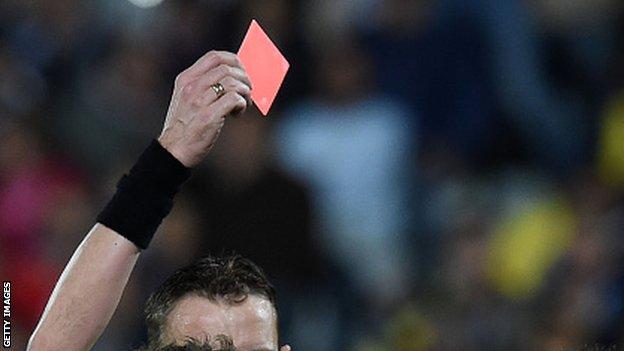 Referee holds red card