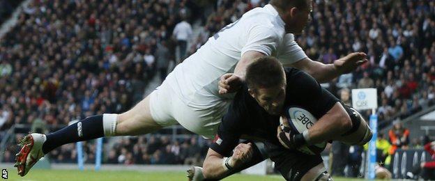 Richie McCaw, right, dives over the line to score a try despite England's Dylan Hartley attempt to tackle during their international rugby union match at Twickenham stadium