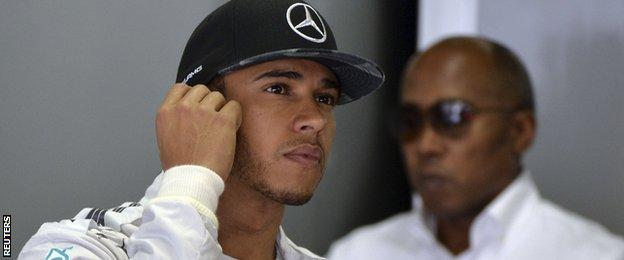 Lewis Hamilton (L) stands on the box next to his father Anthony during the qualifying session of the Brazilian F1 Grand Prix at Interlagos circuit in Sao Paulo November 8, 2014.