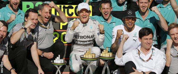 Nico Rosberg (C) of Germany and second placed Mercedes Formula One driver Lewis Hamilton (3rd R) of Britain pose for the official photo with staff after the Brazilian Grand Prix in Sao Paulo November 9, 2014.