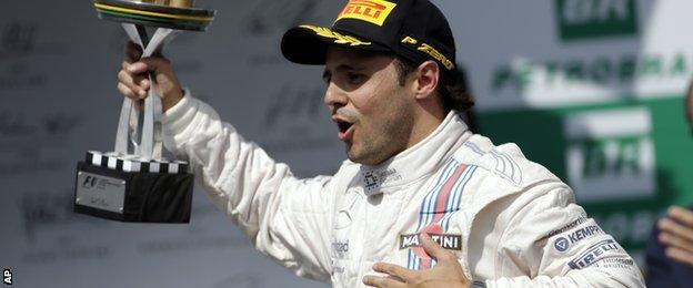 Williams driver Felipe Massa from Brazil, holds his trophy while celebrating after he finished third in the Formula One Brazilian Grand Prix at the Interlagos race track in Sao Paulo, Brazil, Sunday, Nov. 9, 2014.