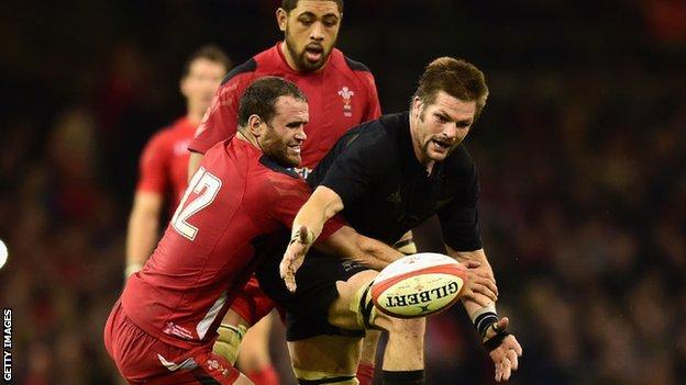 Richie McCaw is tackled by Jamie Roberts
