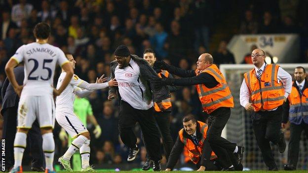 A pitch invader is apprehended at White Hart Lane