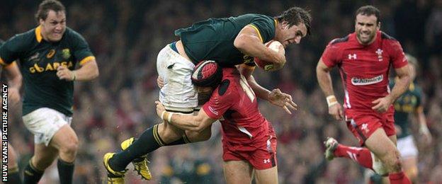 Wales's Leigh Halfpenny tackles Eben Etzebeth of South Africa