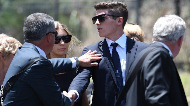 Sean Abbott, who bowled the ball that struck Phillip Hughes, is comforted as he arrives at Hughes's funeral