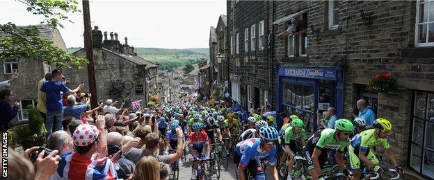 Crowds watch the Peloton ride up Haworth High Street during Stage Two of the Yorkshire Tour de France