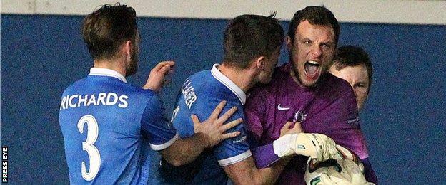 Ross Glendinning is congratulated by team-mates Jimmy Callacher and Jamie Richards after his late penalty save