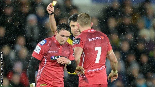 Kristian Phillips (L) is sent to the sin-bin by referee Marius Mitrea during the Scarlets' defeat by Ospreys