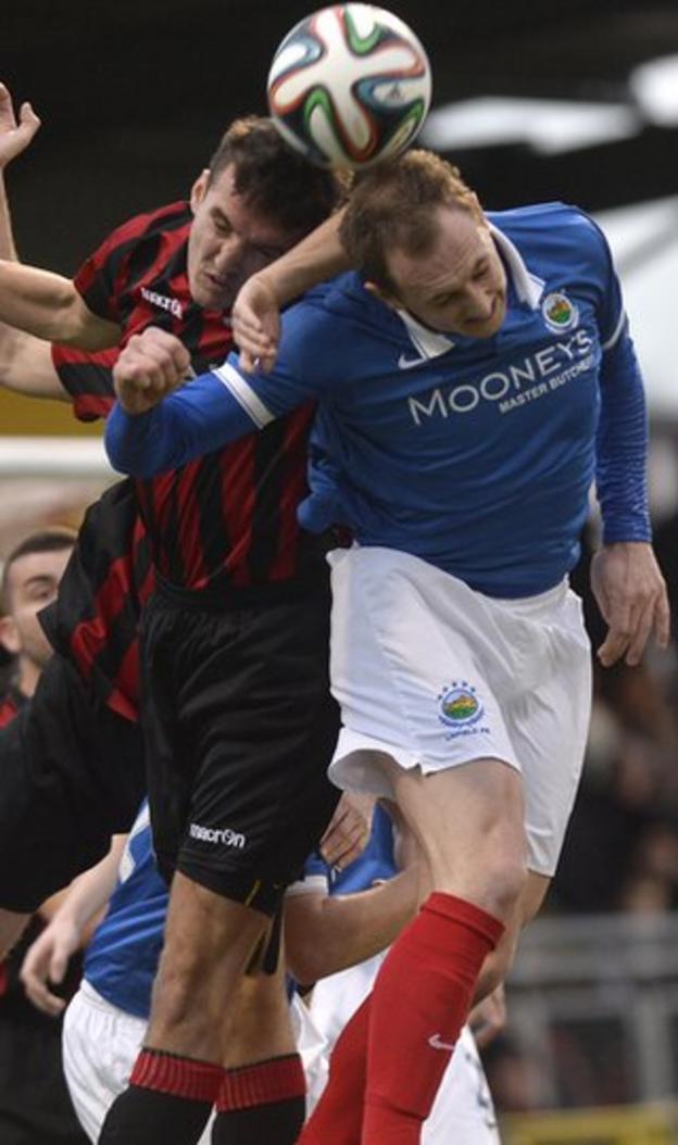 Josh Robinson and Linfield midfielder Sammy Morrow battle for the high ball in the 2-1 win for Crusaders which leaves them just a point behind the Blues