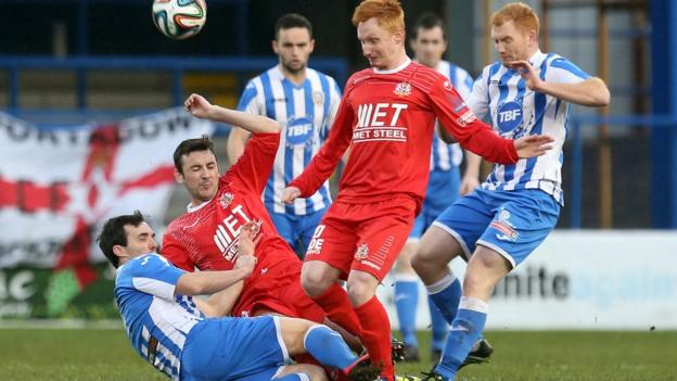 Coleraine's Shane McGinty goes in with a tackle on Portadown pair Michael Gault and Robert Garrett at the Showgrounds
