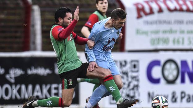 Glentoran midfielder Niall Henderson gets his foot in ahead of Institute's Paul McVeigh at the Oval