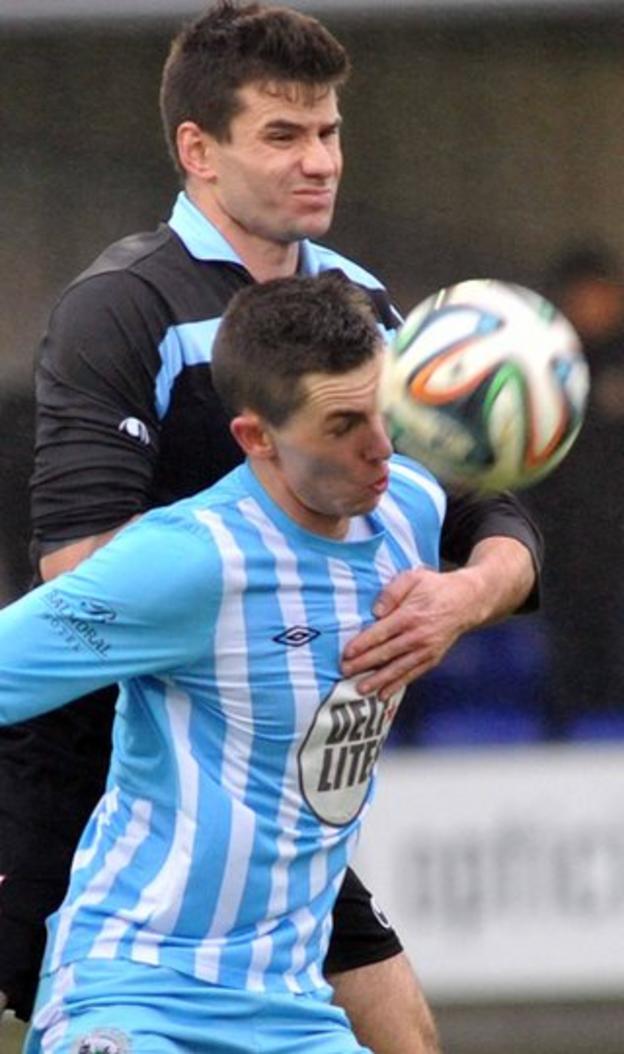 United's Mark McCullagh rises above Daniel Hughes, who netted both goals for Warrenpoint in their 2-0 victory on Thursda