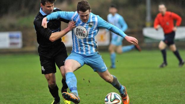 Ballymena United defender Mark McCullagh challenges Warrenpoint Town striker Ciaran O'Connor at Milltown
