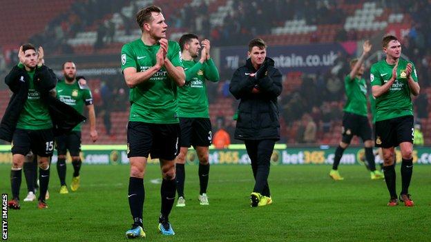 Wrexham players applaud the fans after their FA Cup third-round defeat at Stoke City