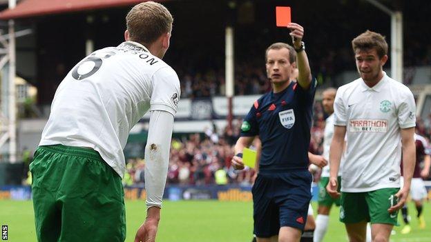 Referee Willie Collum brandishes a red card to Hibernian's Scott Robertson against Hearts