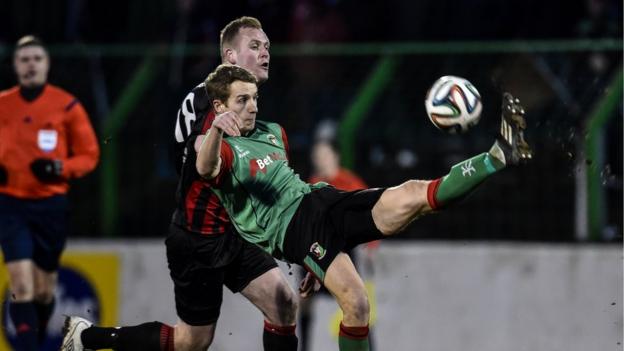 Glentoran's Johnny Addis tries to clear the danger as Jordan Owens closes in during Crusaders' 2-1 victory at the Oval