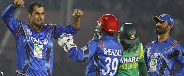 Mohammad Nabi (left) celebrates a wicket