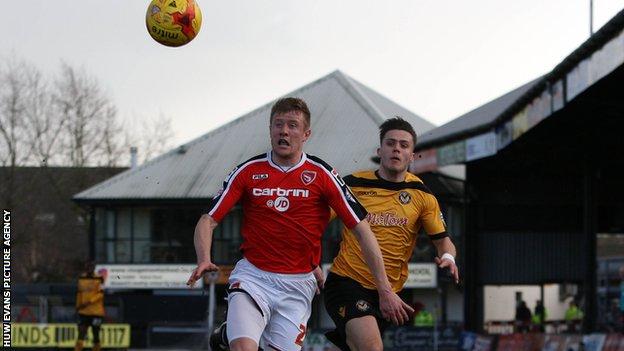 Newport County's Miles Storey and Shaun Beeley of Morecambe in action